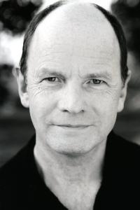Simon Chandler as Father Sykes in The Old Guard (07/2020)